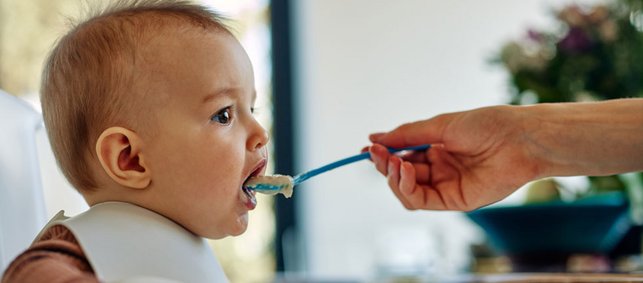 Ein Baby wird mit Brei gefüttert