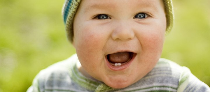 Lachendes Baby mit zwei Zähnen