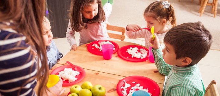Kinder essen im Kindergarten.