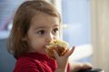 Ein etwa zweijähriges Mädchen isst ein weiches Stück Fladenbrot mit Sesam.