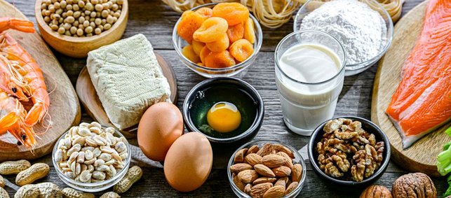 Auf einem Tisch stehen typische Lebensmittel, die Allergien auslösen, wie Eier, Milchprodukte, Fisch