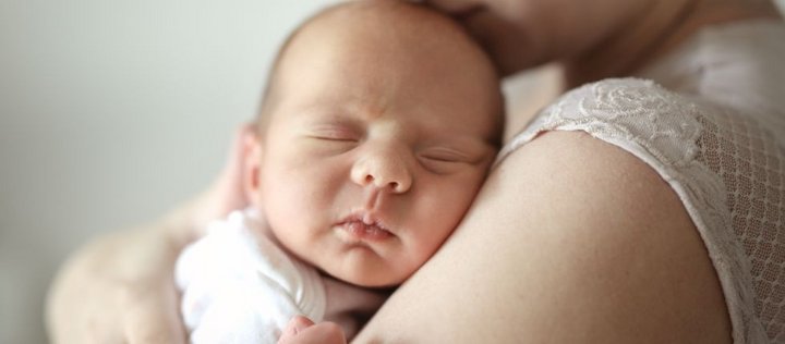 Baby kuschelt auf dem Arm der Mutter