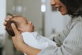 Eine Frau und ein baby sind im profil zu sehen, sie sind einander zugewandt. Die Frau hält das Baby in den Armen.