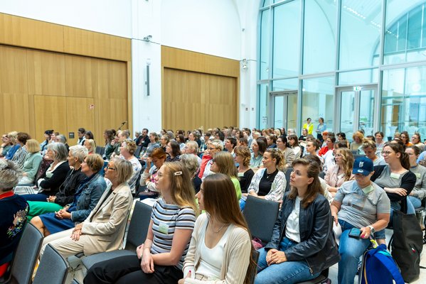 Die Besucherinnen und Besucher des Fachtags "Schwangere begleiten". Ein Blick auf die gefüllten Sitzreihen.