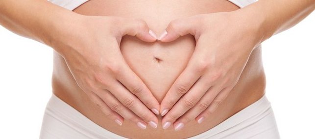 Hände als Herz vor Babybauch