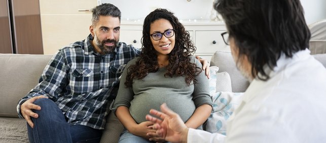 Arzt berät schwangeres Paar