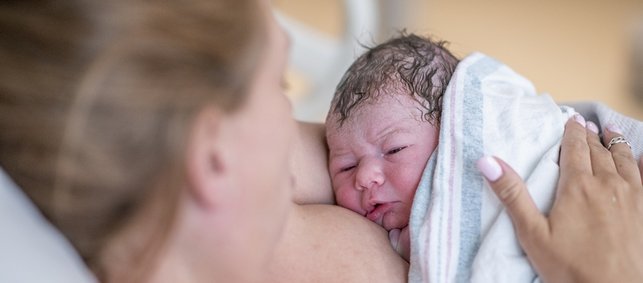 Mutter mit Neugeborenem im Hautkontakt