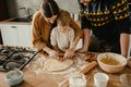 Mutter, Vater und Kleinkind backen in der Küche Weihnachtsplätzchen.