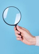 Eine Hand hält eine Lupe