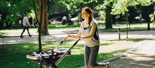 Frau joggt mit Kinderwagen