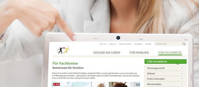 Frau zeigt auf Laptop