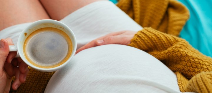 Schwangere hält eine Kaffeetasse