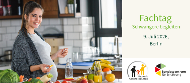 Schwangere steht in ihrer Küche und probiert Obst und Gemüse.