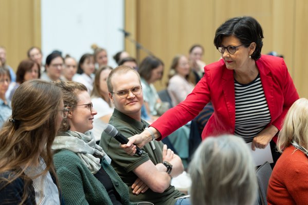 Moderatorin Christiane Poertgen hält das Mikro einer Zuhörerin hin