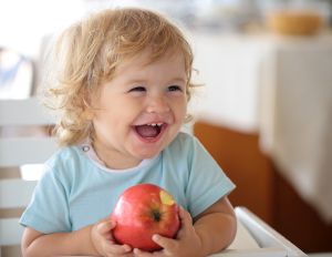 Kleinkind mit Apfel in den Händen