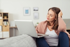 Frau nachdenklich am Laptop