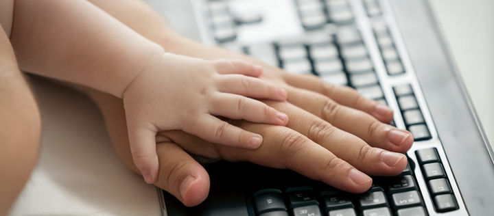 Baby und Hand auf Tastatur