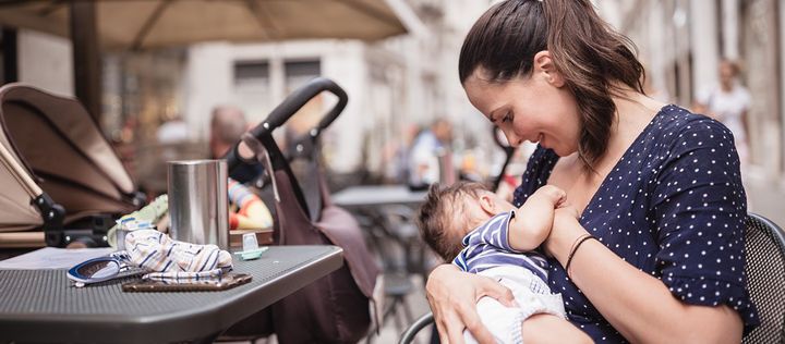 Frau stillt Baby in Cafe